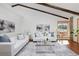 Stylish living room featuring hardwood floors, beamed ceilings, comfortable seating, and a cozy atmosphere at 1340 Deerpath Trl, Franktown, CO 80116