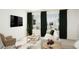 Modern living room boasts large windows with dark curtains, neutral furniture, and contemporary decor at 46533 Sunflower Ln, Bennett, CO 80102