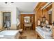 Luxurious bathroom featuring marble countertops, dual sinks, a soaking tub, and designer fixtures at 45 Charlou Cir, Cherry Hills Village, CO 80111