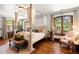 Comfortable bedroom with a four-poster bed, hardwood floors, and plenty of natural light at 45 Charlou Cir, Cherry Hills Village, CO 80111