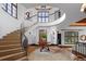 Stunning two-story foyer with curved staircase, iron railing, and travertine floors leading to other rooms in the house at 45 Charlou Cir, Cherry Hills Village, CO 80111