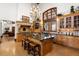 Gourmet kitchen with a large center island, custom cabinetry, stone hood, and high-end appliances at 45 Charlou Cir, Cherry Hills Village, CO 80111