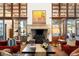 Bright living room with tall wood-framed windows, a stone fireplace, and elegant decor for a refined ambiance at 45 Charlou Cir, Cherry Hills Village, CO 80111