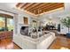 Spacious living room featuring wood-beamed ceiling, fireplace, large windows, and elegant chandelier lighting at 45 Charlou Cir, Cherry Hills Village, CO 80111