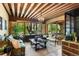 Cozy living room with wood-beamed ceiling, large windows overlooking the lush backyard, and comfortable seating at 45 Charlou Cir, Cherry Hills Village, CO 80111