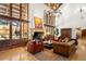 Elegant living room with a stone fireplace, high ceilings and large glass windows looking out to the backyard pool at 45 Charlou Cir, Cherry Hills Village, CO 80111