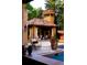 Outdoor fireplace, seating and partial view of the pool and patio area at 45 Charlou Cir, Cherry Hills Village, CO 80111
