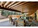 Relaxing covered patio with comfortable seating, a wood-beamed ceiling, and scenic views at 45 Charlou Cir, Cherry Hills Village, CO 80111