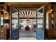 Elegant patio with comfortable seating, wooden ceiling, chandelier, and views from the open doorway at 45 Charlou Cir, Cherry Hills Village, CO 80111