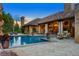 Outdoor pool and patio with view of luxurious house, and an outdoor sitting area with lounge chairs at 45 Charlou Cir, Cherry Hills Village, CO 80111