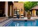 Outdoor pool with chairs, covered patio, and a staircase leading up to the next level of the home at 45 Charlou Cir, Cherry Hills Village, CO 80111