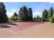 Spacious tennis court with a well-maintained surface and surrounding trees at 45 Charlou Cir, Cherry Hills Village, CO 80111