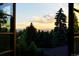 Scenic view of trees and mountains from a window, casting a warm glow at sunset at 45 Charlou Cir, Cherry Hills Village, CO 80111