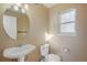 Powder room with pedestal sink, modern toilet, and window providing natural light at 3829 Odessa St, Denver, CO 80249