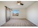 Spacious bedroom featuring a modern ceiling fan and a sliding barn door at 3829 Odessa St, Denver, CO 80249