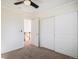 Bedroom featuring ceiling fan, closet, neutral carpet, and access to landing at 3829 Odessa St, Denver, CO 80249