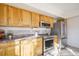 Knotty wood kitchen cabinets, stainless steel oven, microwave and refrigerator, and tiled backsplash at 3829 Odessa St, Denver, CO 80249