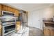 Kitchen with stainless steel appliances, knotty wood cabinets, tiled floors, and a door to an adjacent room at 3829 Odessa St, Denver, CO 80249