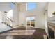 Sun-filled living room with high ceilings, a cozy fireplace, hardwood floors and staircase at 3829 Odessa St, Denver, CO 80249