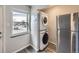 Laundry room featuring stackable washer and dryer and a stainless steel refrigerator at 3259 N Adams St, Denver, CO 80205
