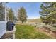 Landscaped backyard with grass, mature trees, a white fence, and patio at 10456 Carriage Club Dr, Lone Tree, CO 80124