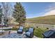 Grassy backyard with patio, two chairs, and a hill at 10456 Carriage Club Dr, Lone Tree, CO 80124
