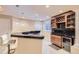 Basement bar featuring a sink, bar seating, wine storage, and tile flooring at 10456 Carriage Club Dr, Lone Tree, CO 80124