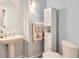 Charming half-bathroom with pedestal sink, storage cabinet, and decorative fixtures at 10456 Carriage Club Dr, Lone Tree, CO 80124