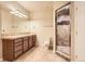 Bathroom with a large mirror, granite countertops, and glass-enclosed shower at 10456 Carriage Club Dr, Lone Tree, CO 80124