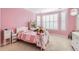 A pink bedroom includes a desk, large window with shutters, and light carpet at 10456 Carriage Club Dr, Lone Tree, CO 80124