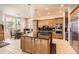 Gourmet kitchen features a center island, stainless steel appliances, and custom cabinetry at 10456 Carriage Club Dr, Lone Tree, CO 80124