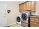 Convenient laundry room featuring washer, dryer, and storage cabinets at 10456 Carriage Club Dr, Lone Tree, CO 80124