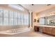 Bright main bathroom features a soaking tub, dual vanity, and plenty of natural light from large windows at 10456 Carriage Club Dr, Lone Tree, CO 80124