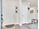 Bright entryway featuring light wood floors, white doors, and framed photos adorning the walls at 330 High Point Dr # B102, Longmont, CO 80504