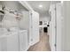 Bright laundry room featuring a full-size washer and dryer with storage shelving at 330 High Point Dr # B102, Longmont, CO 80504