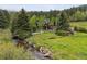 Charming home surrounded by trees, complemented by a creek and lush greenery at 4230 S Meadow Brook Ln, Evergreen, CO 80439