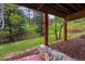 A lush green lawn and red-rock patio seating area complete this home's lovely backyard at 4230 S Meadow Brook Ln, Evergreen, CO 80439