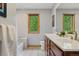 Bright bathroom with double vanity, modern fixtures, and window with wooded view at 4230 S Meadow Brook Ln, Evergreen, CO 80439