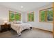 Cozy bedroom with natural light from windows showcasing wooded views at 4230 S Meadow Brook Ln, Evergreen, CO 80439
