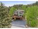 Beautiful multi-story home surrounded by tall trees, and scenic views at 4230 S Meadow Brook Ln, Evergreen, CO 80439