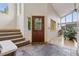 Bright foyer with a stained-glass front door, open staircase, and views to the living room at 4230 S Meadow Brook Ln, Evergreen, CO 80439