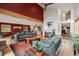 Open-concept living space with hardwood floors, vibrant red accent wall, and views into the kitchen at 4230 S Meadow Brook Ln, Evergreen, CO 80439