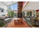 Inviting living room with a stone fireplace, high ceilings, ample natural light, and outside access at 4230 S Meadow Brook Ln, Evergreen, CO 80439