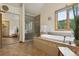 Bright main bathroom with garden tub, glass shower, and scenic outdoor views at 4230 S Meadow Brook Ln, Evergreen, CO 80439