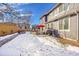 Backyard with patio and grill, partial snow cover at 10551 Applebrook Cir, Highlands Ranch, CO 80130