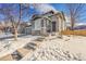 Two-story home with gray siding, stone accents, and a snow-covered front yard at 10551 Applebrook Cir, Highlands Ranch, CO 80130