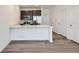 Open kitchen boasts a large center island with quartz countertops, stainless appliances and hard wood floors at 1986 S Haleyville Way, Aurora, CO 80018