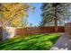 Spacious backyard with lush green grass and a tall wooden fence at 7904 Chase Cir # 146, Arvada, CO 80003