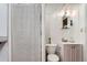 Compact bathroom with toilet, vanity, mirror, and shower with a white curtain at 3246 W 53Rd Ave, Denver, CO 80221