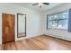 Sunlit bedroom showcasing hardwood floors, large window, and convenient closet access at 3246 W 53Rd Ave, Denver, CO 80221